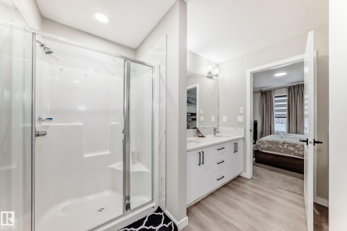 Ensuite bathroom featuring a shower stall, double vanity, light wood finished floors, and recessed lighting - 4930 Hawthorn Place, Edmonton, AB - Indoor Photo Showing Bathroom