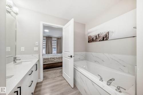 Ensuite bathroom featuring double vanity, a bath, and light wood-style flooring - 4930 Hawthorn Place, Edmonton, AB - Indoor Photo Showing Bathroom