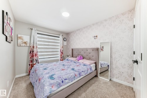 Bedroom with wallpapered walls and light colored carpet - 4930 Hawthorn Place, Edmonton, AB - Indoor Photo Showing Bedroom