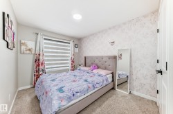 Bedroom with wallpapered walls and light colored carpet - 