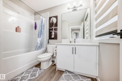Full bath featuring vanity, shower / bath combination with curtain, and light wood-type flooring - 