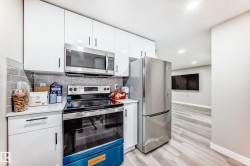 Kitchen featuring stainless steel appliances, white cabinets, light wood finished floors, recessed lighting, and modern cabinets - 