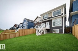 Rear view of property featuring stairs, a fenced backyard, a wooden deck, and a residential view - 