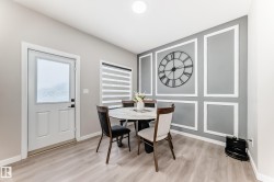 Dining area with light wood-style flooring and a decorative wall - 