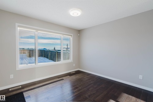 Empty room with baseboards and dark wood finished floors - 16627 18 Avenue, Edmonton, AB - Indoor Photo Showing Other Room