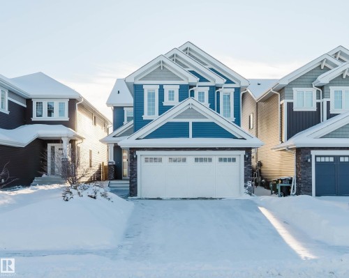 Craftsman house with stone siding, an attached garage, and board and batten siding - 16627 18 Avenue, Edmonton, AB - Outdoor With Facade