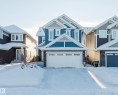 Craftsman house with stone siding, an attached garage, and board and batten siding - 16627 18 Avenue, Edmonton, AB  - Outdoor With Facade 