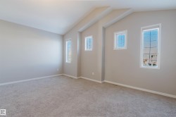Unfurnished room with light carpet and vaulted ceiling - 