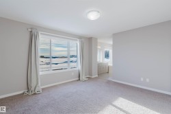 Unfurnished bedroom with baseboards and light colored carpet - 