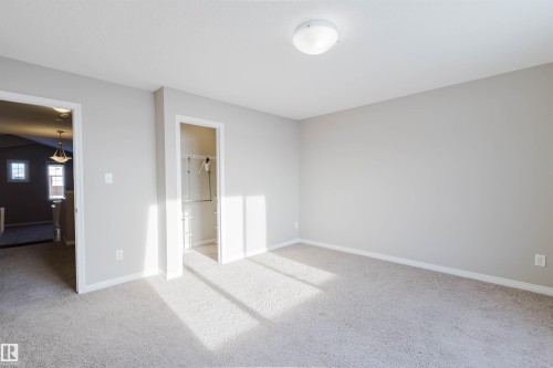 Unfurnished bedroom with light carpet and a walk in closet - 16627 18 Avenue, Edmonton, AB - Indoor Photo Showing Other Room