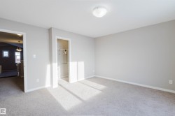Unfurnished bedroom with light carpet and a walk in closet - 