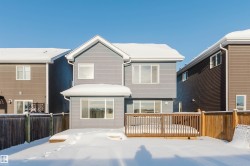 Snow covered house featuring a wooden deck - 