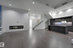 Unfurnished living room with a high ceiling, stairs, dark wood-style floors, and recessed lighting - 