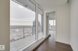 Empty room featuring a city view and dark wood-style flooring - 
