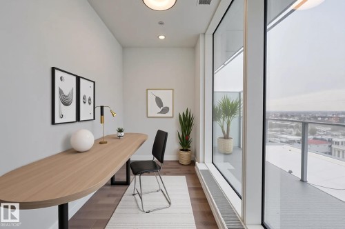 Office area with dark wood-style flooring, floor to ceiling windows, and recessed lighting - 2303 10360 102 Street, Edmonton, AB - Indoor Photo Showing Other Room