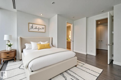 Bedroom with dark wood finished floors, recessed lighting, and ensuite bathroom - 2303 10360 102 Street, Edmonton, AB - Indoor Photo Showing Bedroom