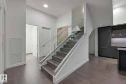 Stairway with wood finished floors, a towering ceiling, and recessed lighting - 