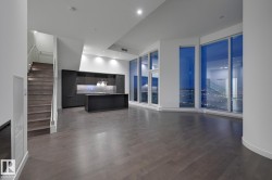 Unfurnished living room with stairway, dark wood-type flooring, recessed lighting, and a towering ceiling - 