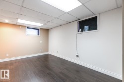 Below grade area with dark wood-type flooring and a paneled ceiling - 