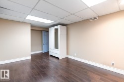 Spare room featuring dark wood-style flooring and a paneled ceiling - 
