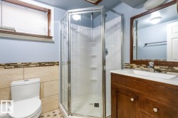 Full bathroom featuring vanity, a shower stall, and tile walls - 