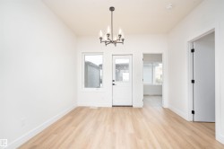 Unfurnished dining area with light wood-style flooring, a chandelier, and plenty of natural light - 