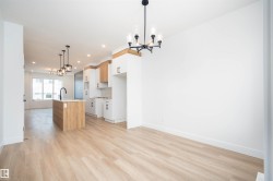 Kitchen featuring a chandelier, decorative light fixtures, an island with sink, open floor plan, and recessed lighting - 