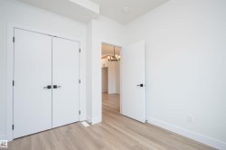 Unfurnished bedroom featuring light wood-style flooring, a closet, and a chandelier - 