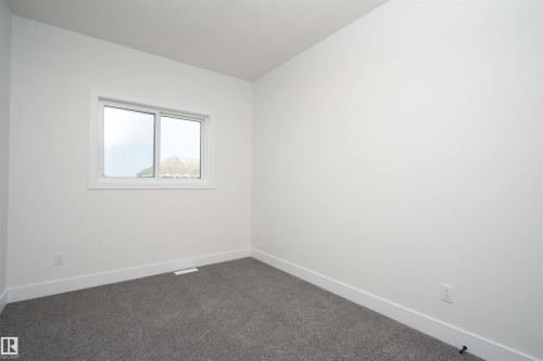 Spare room featuring baseboards and dark colored carpet - 430 Crystal Creek Link, Leduc, AB - Indoor Photo Showing Other Room