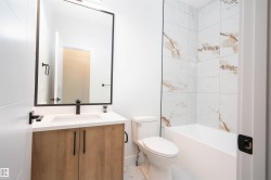 Bathroom with vanity, tub / shower combination, and light marble finish floors - 