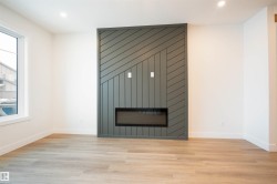Detailed view of wood finished floors, a fireplace, and recessed lighting - 