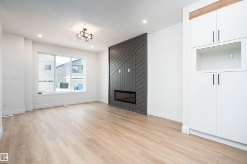 Unfurnished living room featuring light wood finished floors, a large fireplace, and recessed lighting - 430 Crystal Creek Link, Leduc, AB - Indoor Photo Showing Other Room With Fireplace