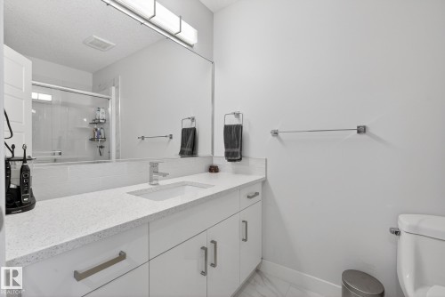 Bathroom featuring vanity, a shower stall, light marble finish floors, and a textured ceiling - 17727 13 Avenue, Edmonton, AB - Indoor Photo Showing Bathroom