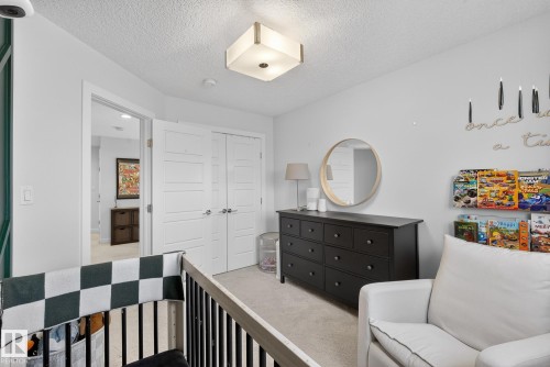 Bedroom with light colored carpet, a closet, and a textured ceiling - 17727 13 Avenue, Edmonton, AB - Indoor