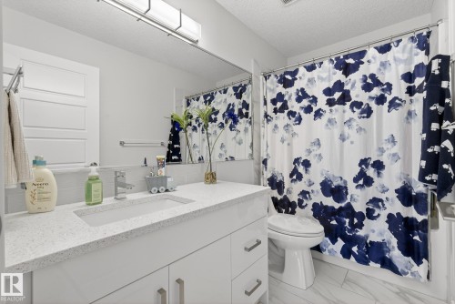 Full bathroom with a textured ceiling, vanity, and light marble finish flooring - 17727 13 Avenue, Edmonton, AB - Indoor Photo Showing Bathroom