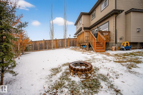 Snowy yard featuring a wooden deck and a fire pit - 17727 13 Avenue, Edmonton, AB - Outdoor