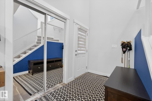 Entrance foyer with healthy amount of natural light, stairway, and tile patterned floors - 17727 13 Avenue, Edmonton, AB - Indoor Photo Showing Other Room