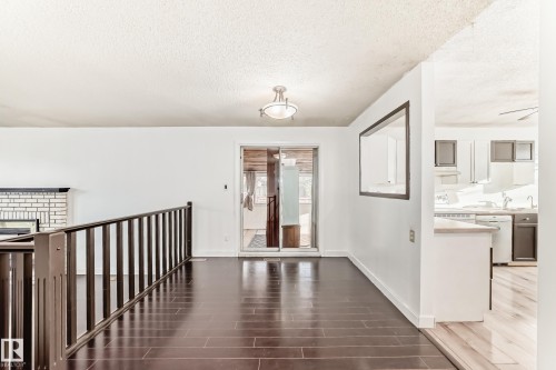 Hallway featuring a textured ceiling and dark wood-style floors - 131 Saskatchewan Avenue W, Devon, AB - Indoor