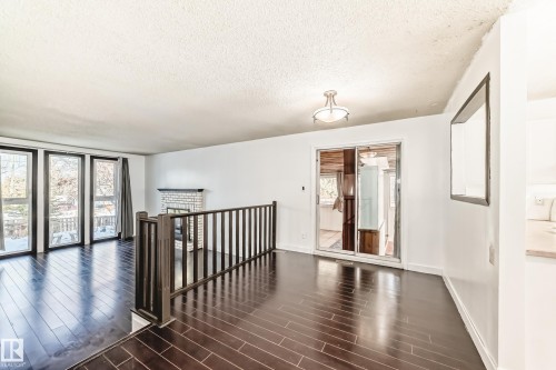 Unfurnished room with dark wood-type flooring and a textured ceiling - 131 Saskatchewan Avenue W, Devon, AB - Indoor Photo Showing Other Room