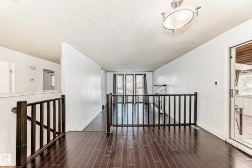Corridor featuring an upstairs landing, a textured ceiling, and dark wood finished floors - 131 Saskatchewan Avenue W, Devon, AB - Indoor Photo Showing Other Room