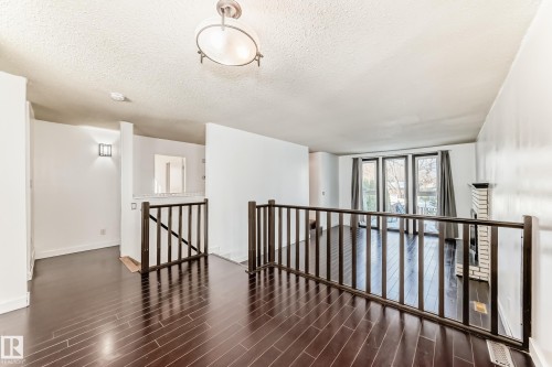 Empty room featuring a textured ceiling and dark wood-style flooring - 131 Saskatchewan Avenue W, Devon, AB - Indoor Photo Showing Other Room