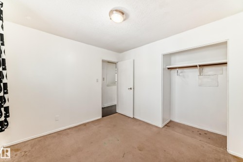 Unfurnished bedroom featuring a closet, carpet floors, and a textured ceiling - 131 Saskatchewan Avenue W, Devon, AB - Indoor Photo Showing Other Room