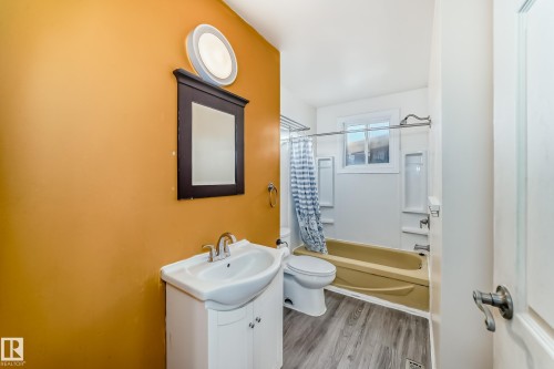Bathroom featuring vanity, light wood-style flooring, and shower / bath combo with shower curtain - 131 Saskatchewan Avenue W, Devon, AB - Indoor Photo Showing Bathroom