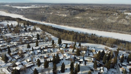 View of property location featuring a heavily wooded area and nearby suburban area - 131 Saskatchewan Avenue W, Devon, AB - Outdoor With View