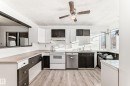Kitchen with white cabinetry, white electric stove, dishwasher, light wood-style floors, and a textured ceiling - 131 Saskatchewan Avenue W, Devon, AB  - Indoor Photo Showing Kitchen 