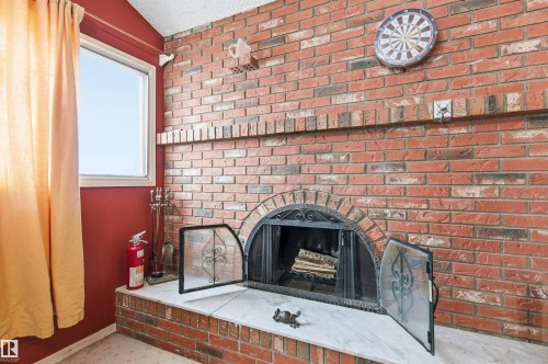 Detailed view of a fireplace and a fire extinguisher - 10332 82 Street, Edmonton, AB - Indoor With Fireplace