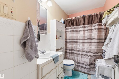 Bathroom with curtained shower, vanity, and tile walls - 10332 82 Street, Edmonton, AB - Indoor Photo Showing Bathroom