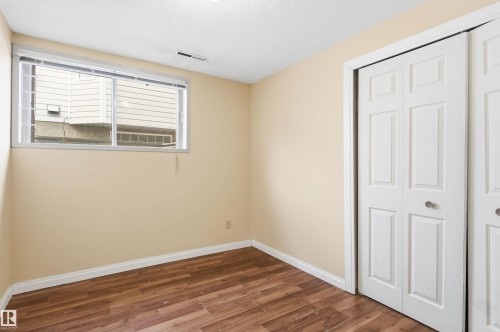 Unfurnished bedroom with wood finished floors, a closet, and a textured ceiling - 10332 82 Street, Edmonton, AB - Indoor Photo Showing Other Room