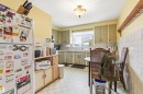 Kitchen with light flooring, freestanding refrigerator, black microwave, light countertops, and decorative backsplash - 10332 82 Street, Edmonton, AB  - Indoor 