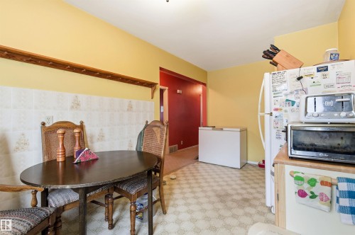 Kitchen featuring white refrigerator and tile walls - 10332 82 Street, Edmonton, AB - Indoor